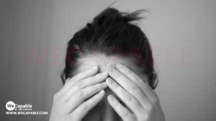 a woman holding her forehead in hands indicating mental illness like stress.